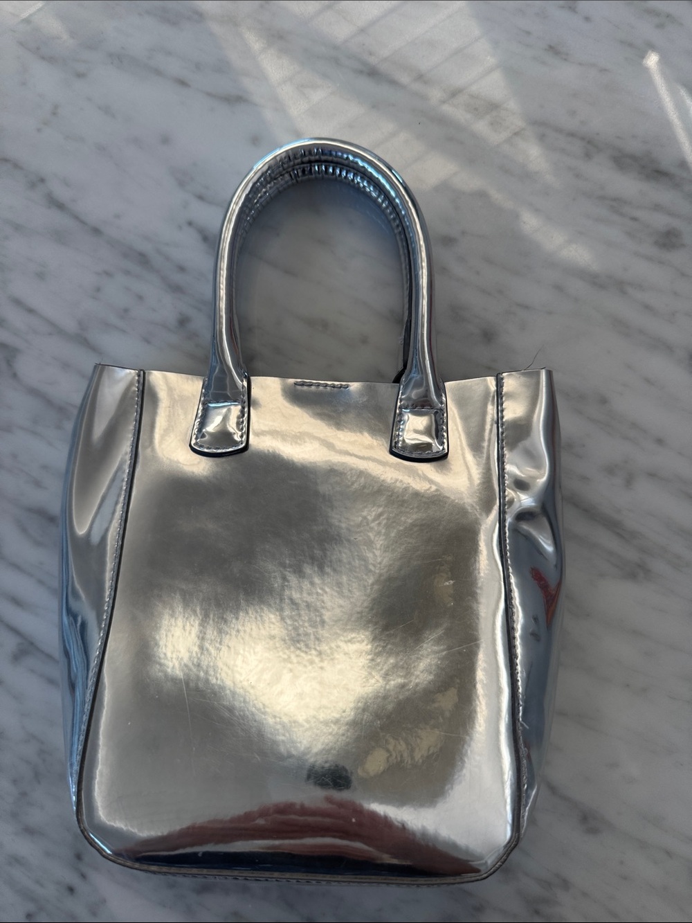 Metallic Silver Mini Tote Bag - Sleek Handheld Style with thin long strap.